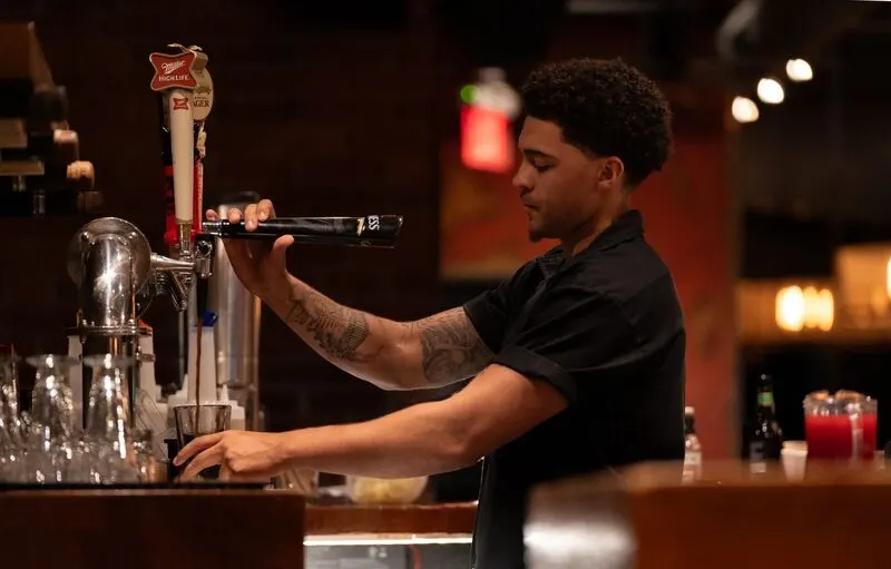 Bartender serving a fresh draft beer